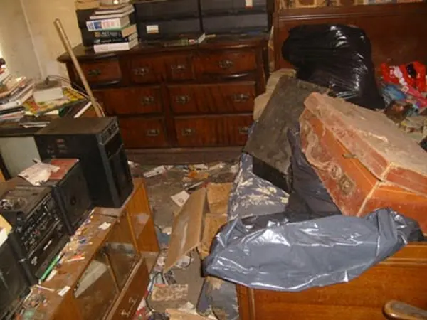 Room filled with bagged rubbish before clearance