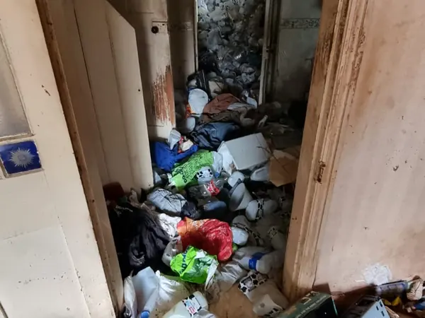 Hallway blocked wall to ceiling with bagged rubbish