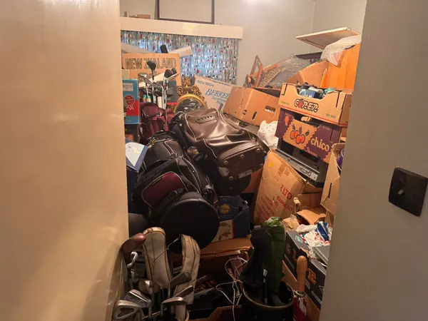 Garage and garden piled with contents before clearance