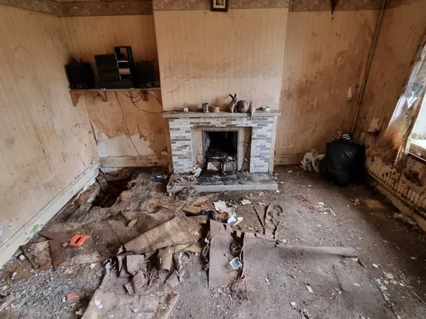 The same room emptied, only the fireplace left