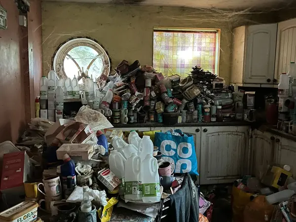Hoarded kitchen and living rooms before clearance