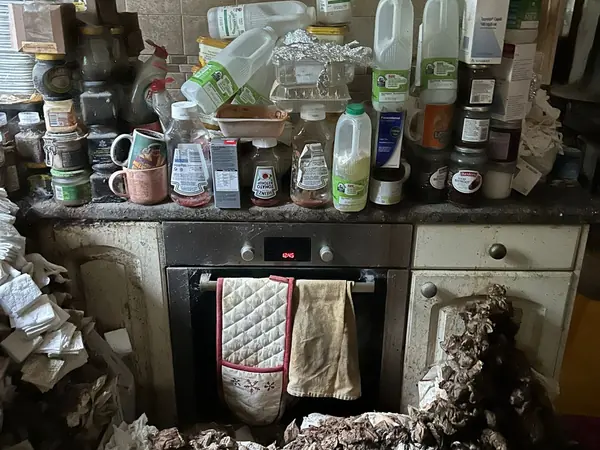 Hoarded kitchen and living rooms before clearance